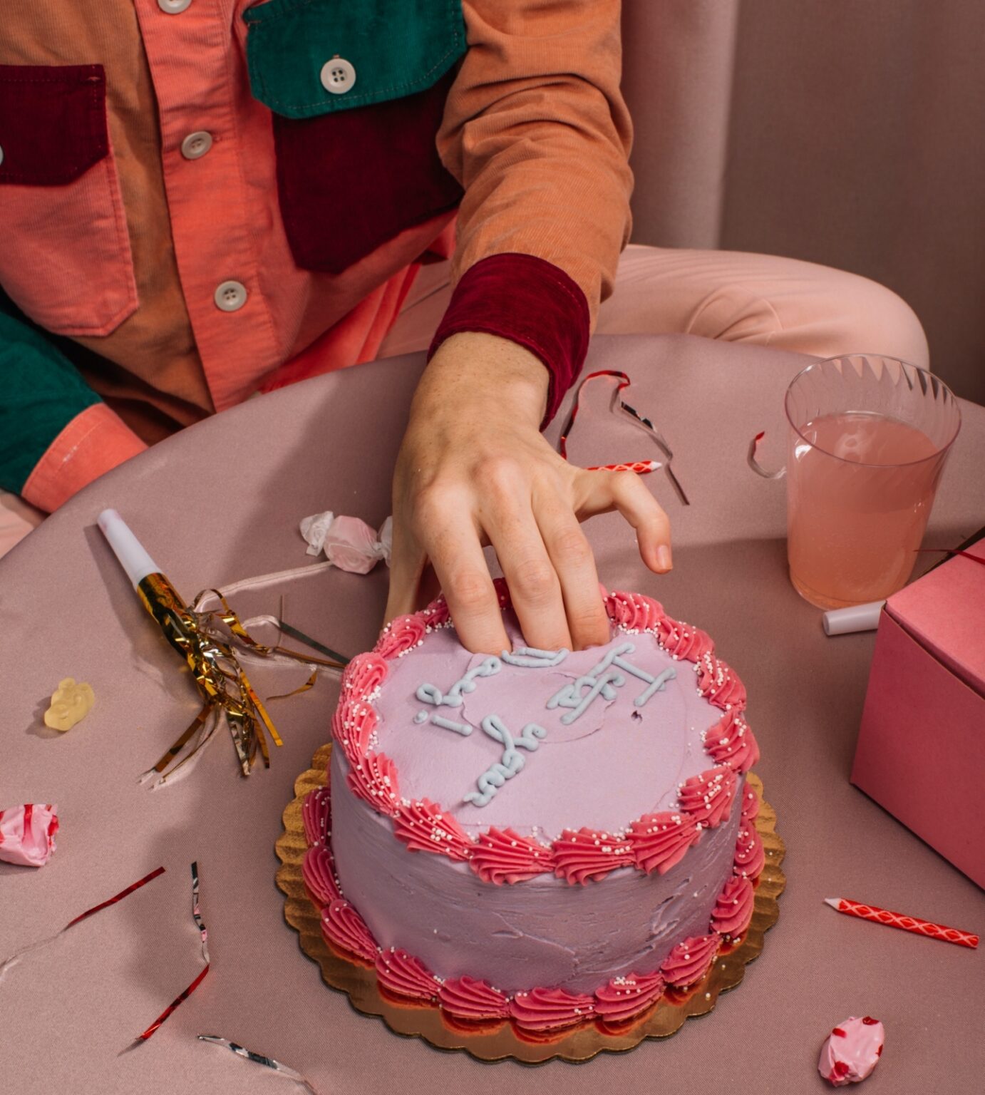 Fingers in pink birthday cake food porn