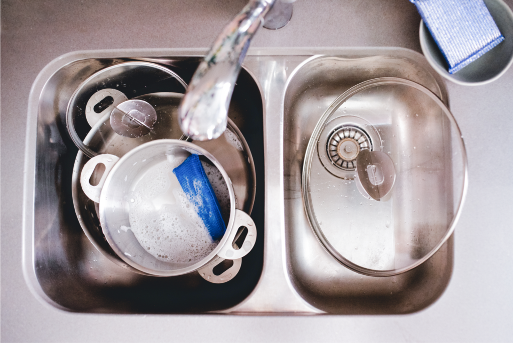 sink with stainless steel cookware and sponge